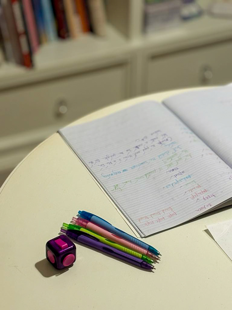 Pencils, dice and notebook on table content